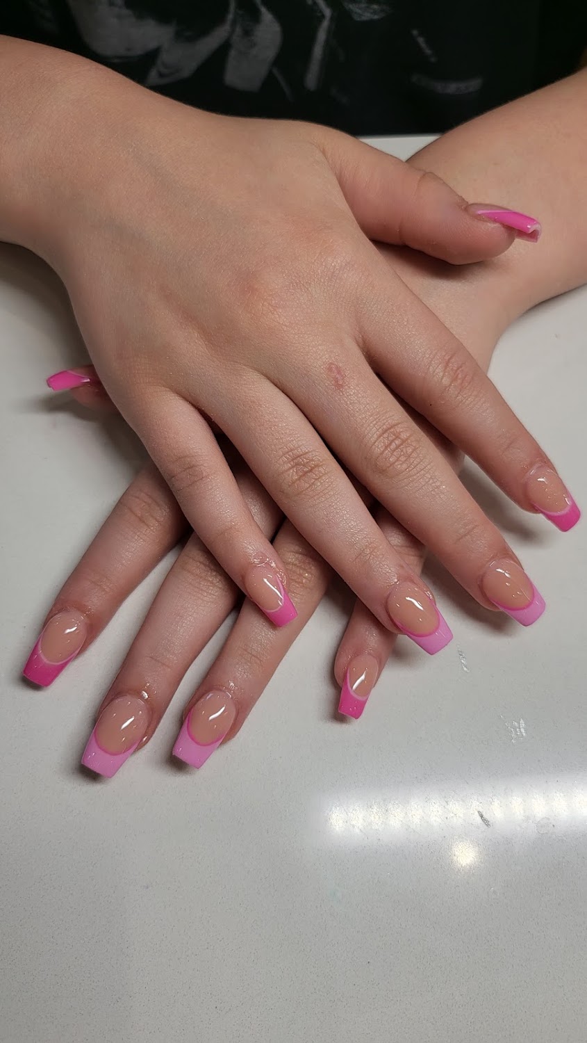 A client's hands with long square nails finished in a pink French tip